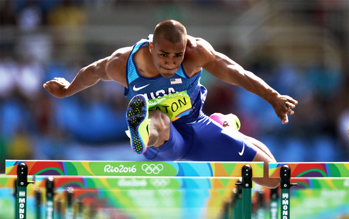 里约奥运会跨栏比赛运动员腾跃过栏，Rio2016场馆品牌背板，赛事现场画面