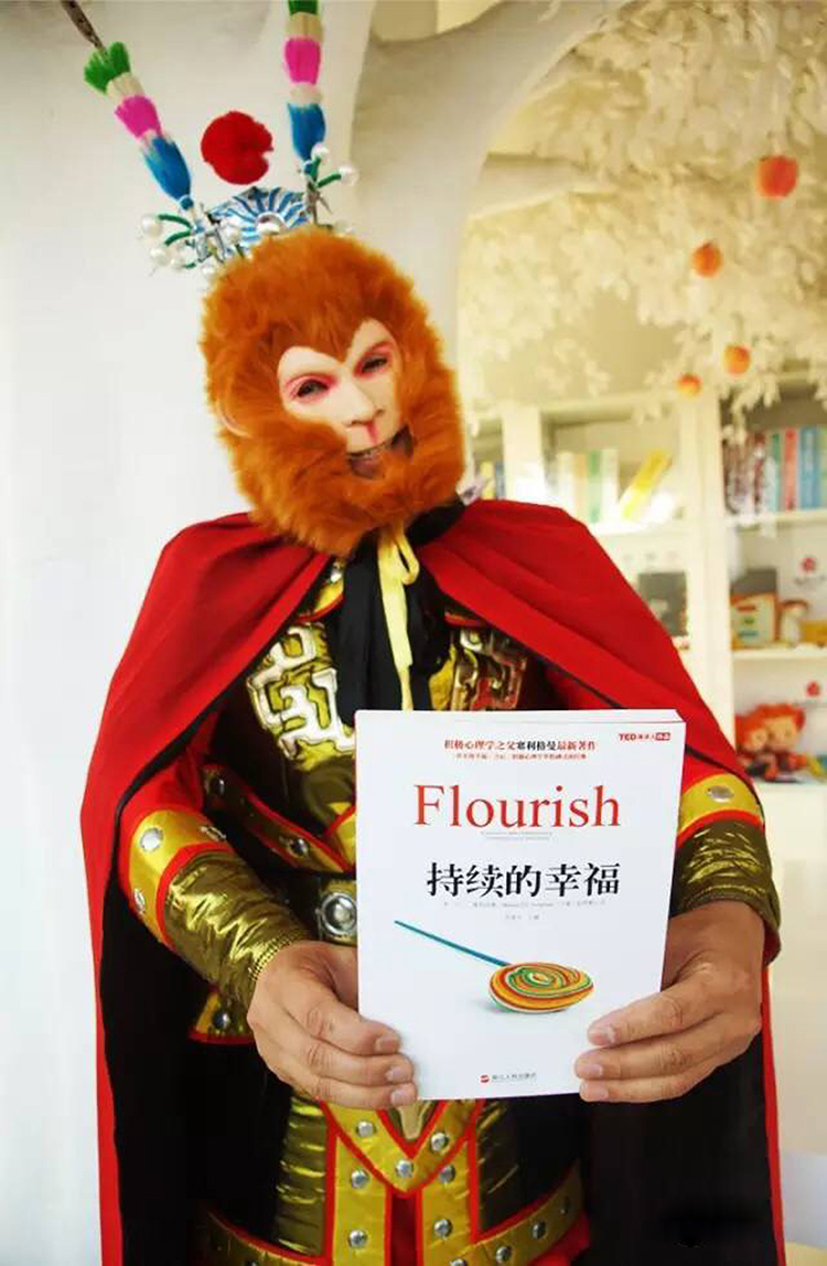 嘉宾身披橙色斗篷手持Flourish书籍扮演橙色青蛙推广积极心理