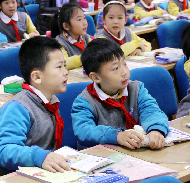 教室内身着蓝色校服佩戴红领巾的学生认真学习场景,丰合五小校园