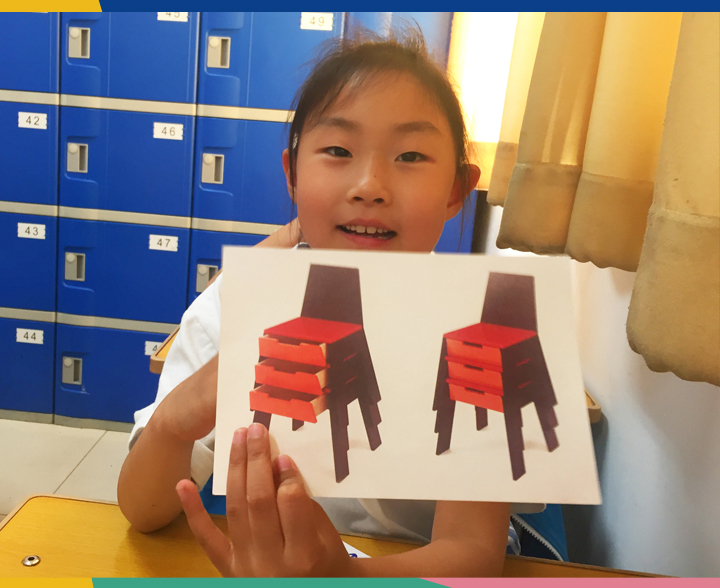史家小学女学生举起手绘红色椅子设计稿,展示创意作品,锦连环设计课堂现场