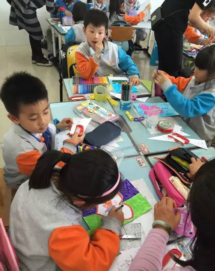 东北旺中心小学学生围坐课桌共同阅读与动手实践，校园学习场景，特色定位文化建设