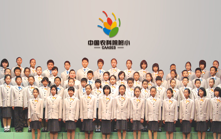 中国农科院附小全校学生身着校服在校徽墙前合影，校园文化建设成果，品牌重塑实景