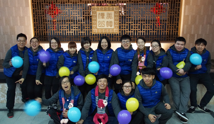 锦连环员工身着蓝衣户外合影,气球装饰增添节日气氛