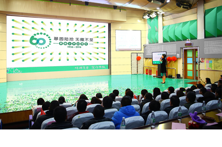 翠微小学六十周年庆典活动现场，礼堂内师生观看舞台庆典表演