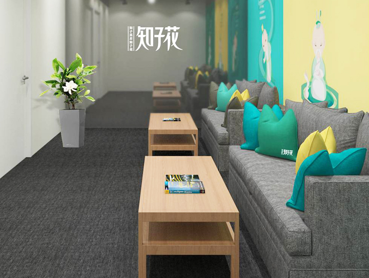 知子花休息等候区，沙发抱枕与茶几绿植搭配品牌墙，锦连环打造温馨教育品牌空间环境