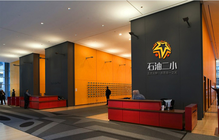 石油二小校园大厅前台空间，橙色调校徽logo墙，锦连环校园文化空间设计