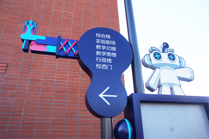海淀实验二小校园导视系统实景,红墙方向指引牌与吉祥物结合的导视设计