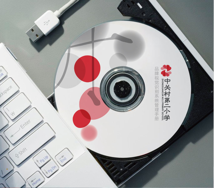 印有中关村二小标志的品牌光盘与键盘场景，VI系统在办公物料上的应用展示
