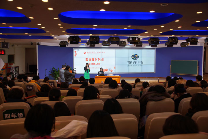 锦连环校园文化培训活动现场，讲师在台上演讲，大屏显示校园文化培训与锦连环标志，台下师生认真聆听